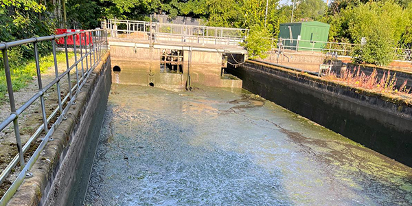 A Stormwater Attenuation Tank before it's cleaned, contaminated with thick sediment and general detritus.